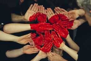 A cluster of hands with a red heart painted across them- Families Advocating for Chemical & Toxics Safety