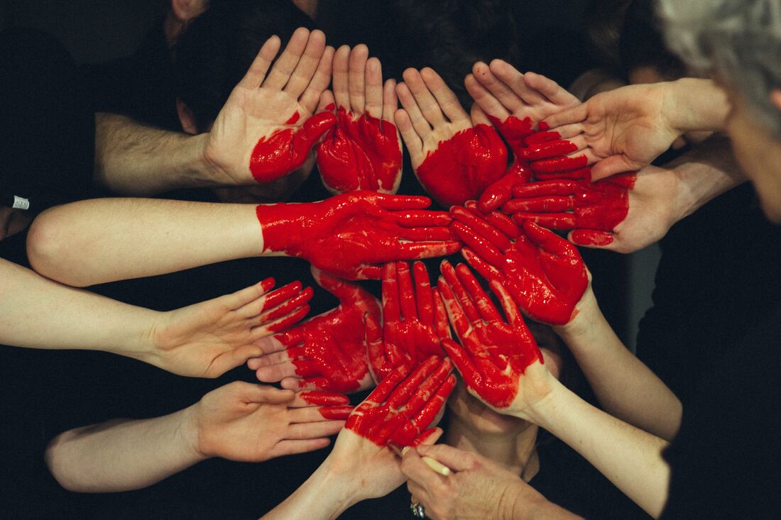 Cluster of hands with a red heart painted across them- Families Advocating for Chemical & Toxics Safety